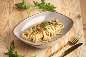 Karamellisierte Zwiebelpasta | Foto: Wolfgang Hummer Nudeln mit cremiger Zwiebelsauce auf beigem Teller